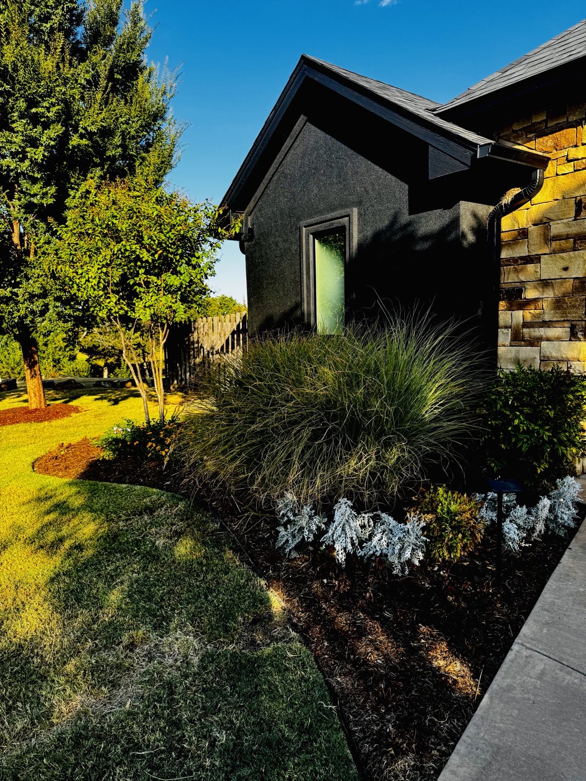 Ornamental grasses and mulch bed landscaping with accent lighting
